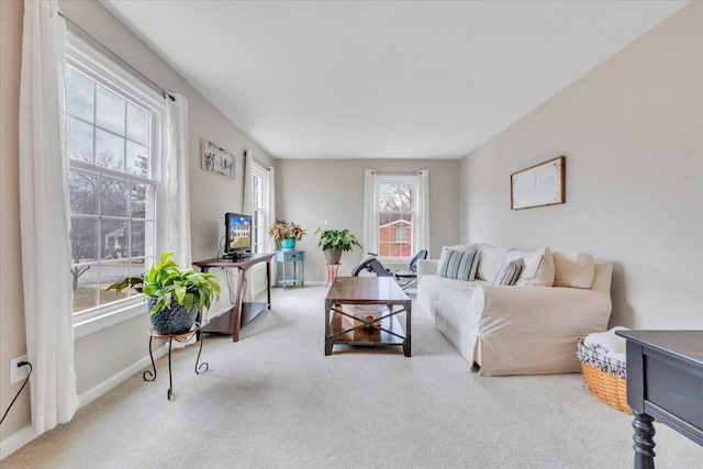 carpeted living area featuring baseboards