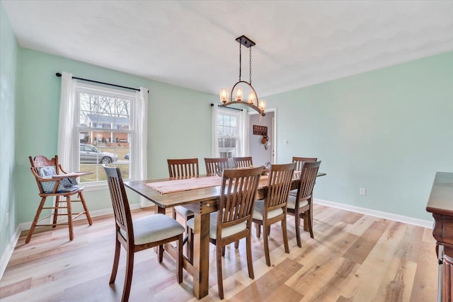 dining room featuring light wood-style flooring and baseboards