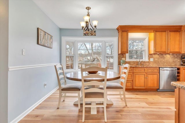 dining room featuring baseboards, a chandelier, and light wood-style floors