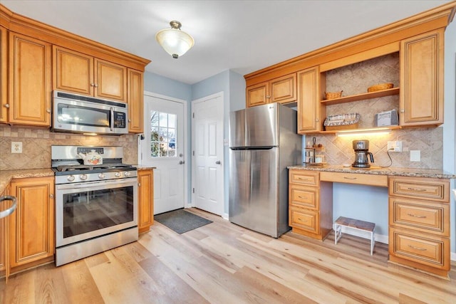 kitchen with stainless steel appliances, tasteful backsplash, light wood-style flooring, and light stone countertops