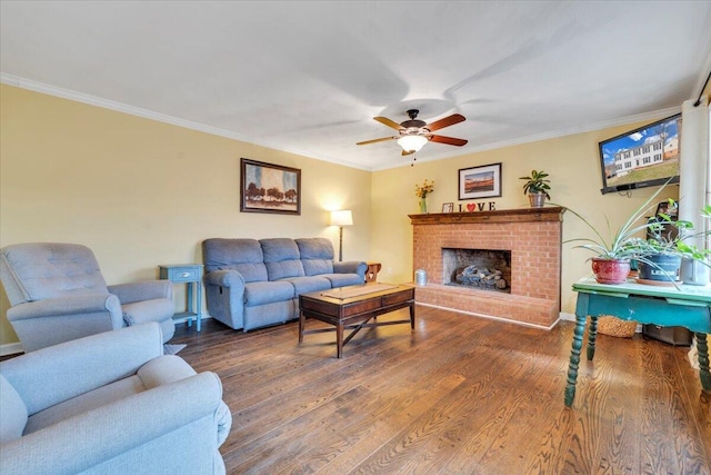 living room with ornamental molding, a fireplace, wood finished floors, and a ceiling fan