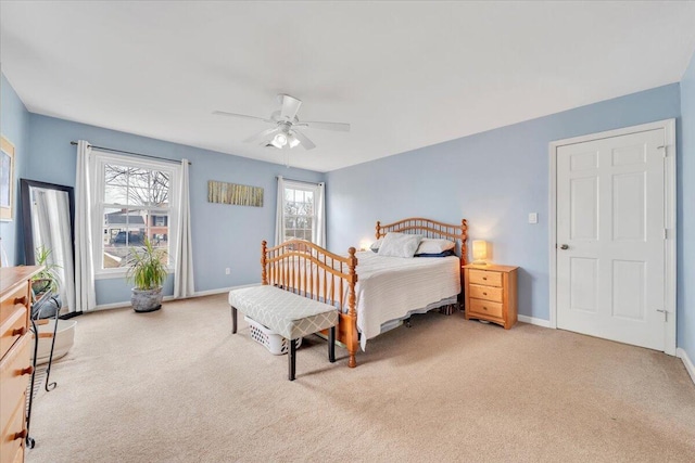 carpeted bedroom with ceiling fan and baseboards