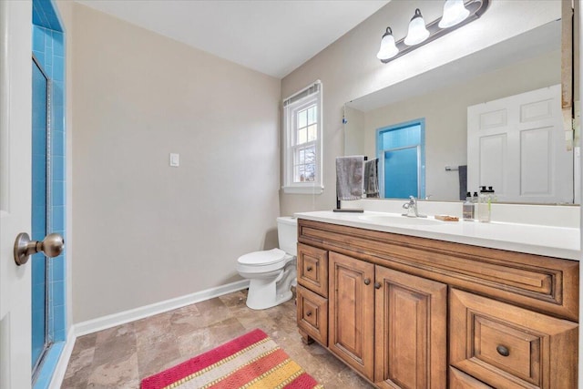 full bathroom with toilet, vanity, a shower with shower door, and baseboards