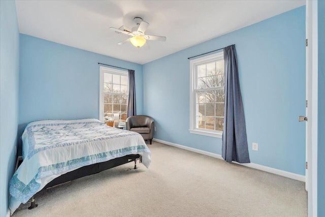 bedroom with carpet floors, multiple windows, baseboards, and a ceiling fan