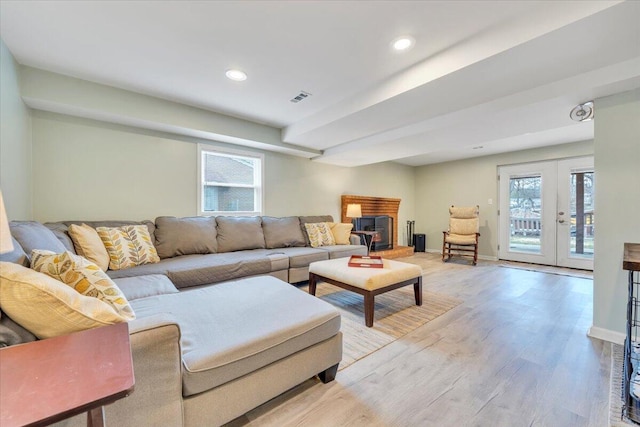 living room featuring baseboards, visible vents, wood finished floors, and french doors