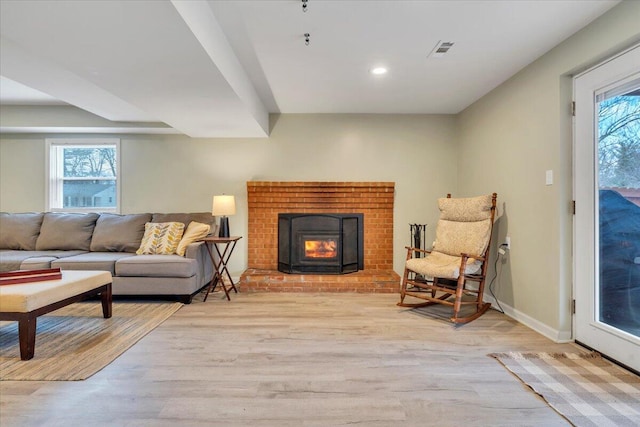 living area with light wood finished floors, recessed lighting, visible vents, a brick fireplace, and baseboards