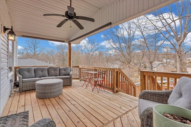 wooden deck with an outdoor living space and a ceiling fan