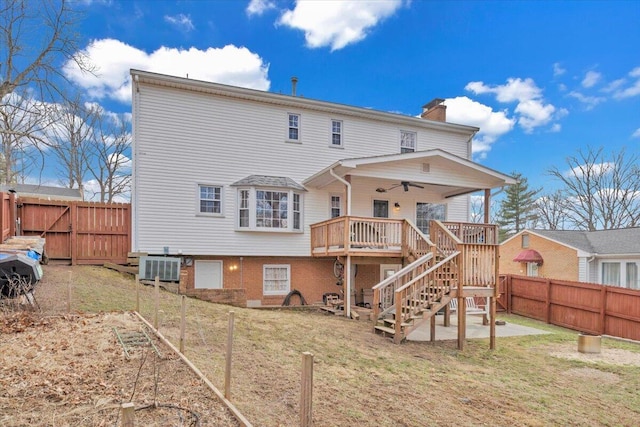 rear view of house featuring a chimney, ceiling fan, a deck, cooling unit, and stairs