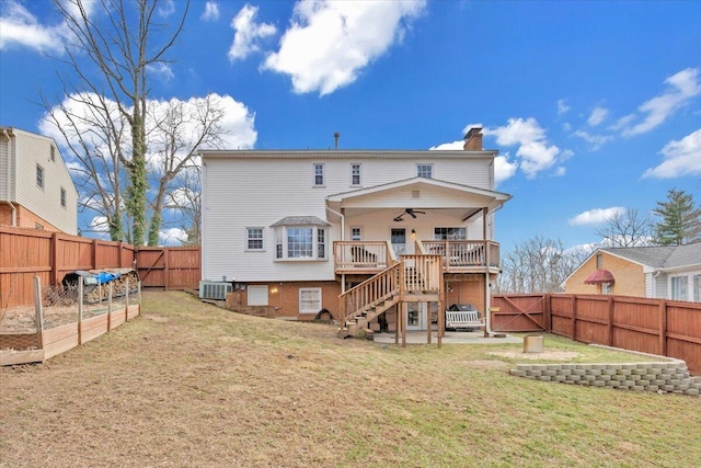 back of property with a yard, a chimney, stairway, central AC unit, and ceiling fan