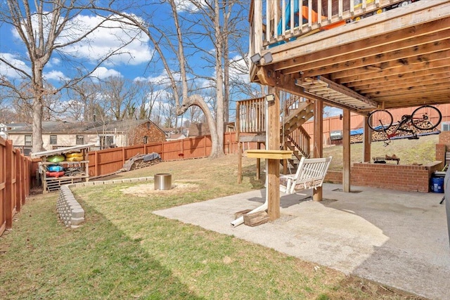 view of yard with a patio area, a fenced backyard, and stairway