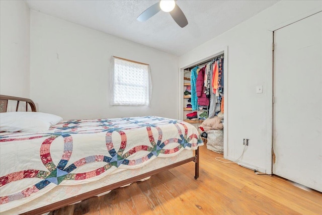 bedroom with light wood-style floors, a textured ceiling, a ceiling fan, and a closet