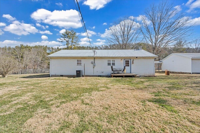 rear view of house with crawl space, a deck, metal roof, and a yard