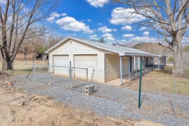 exterior space with a garage, metal roof, and an outdoor structure