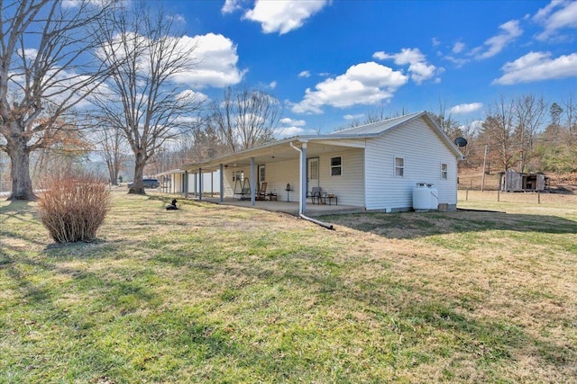 rear view of house featuring a patio area and a lawn