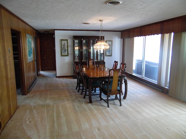 dining room featuring light carpet, wood walls, visible vents, and ornamental molding