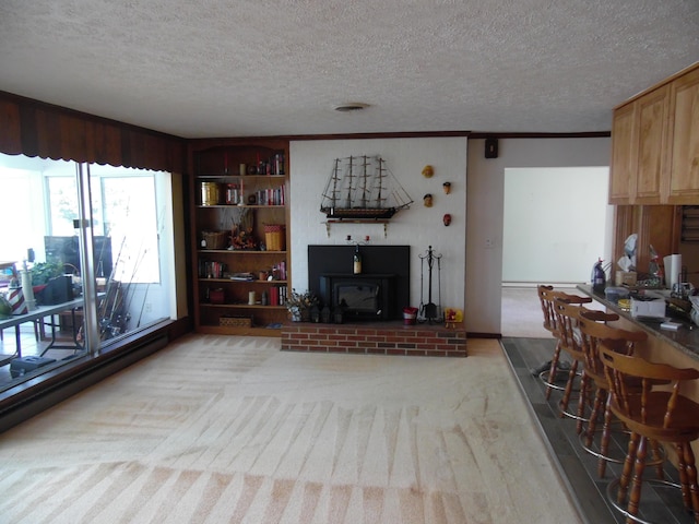 living area with light carpet, built in features, a baseboard radiator, a textured ceiling, and crown molding