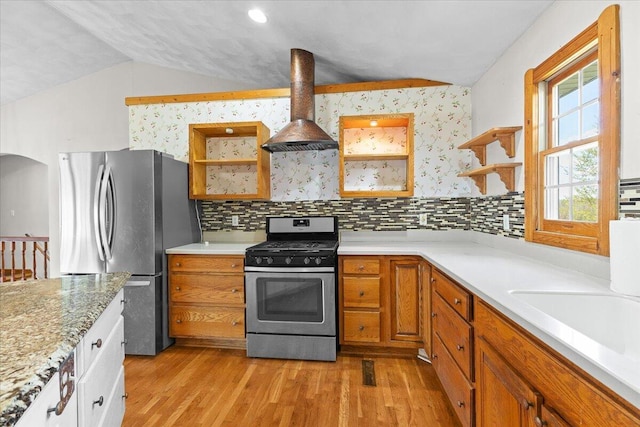 kitchen with stainless steel appliances, island exhaust hood, light wood-style floors, lofted ceiling, and open shelves
