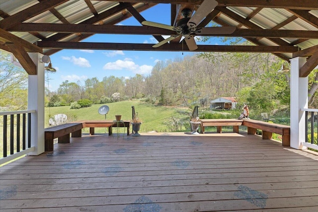 wooden deck featuring a gazebo, a yard, a wooded view, and ceiling fan