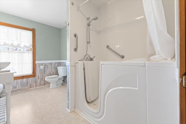 bathroom with wainscoting, walk in shower, and toilet