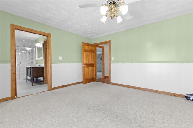 carpeted spare room with baseboards and a ceiling fan