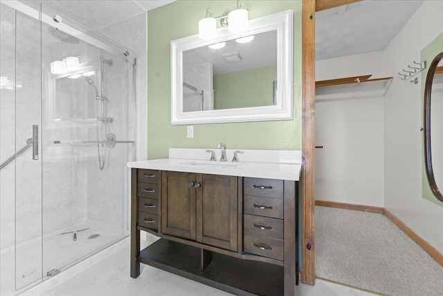bathroom featuring baseboards, vanity, and a shower stall