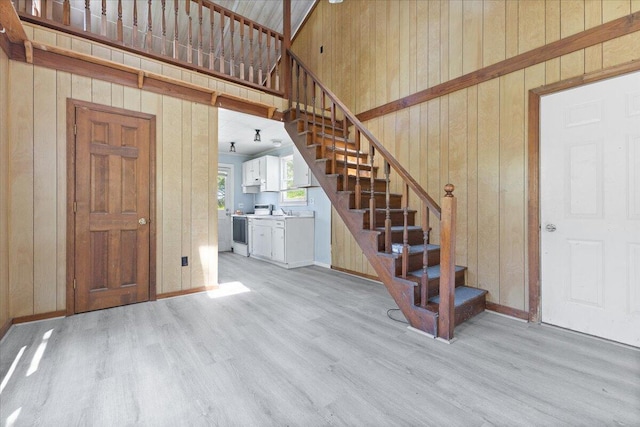 interior space featuring baseboards, wood finished floors, and wooden walls