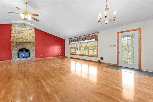 unfurnished living room featuring wood finished floors, a healthy amount of sunlight, lofted ceiling, and ceiling fan with notable chandelier