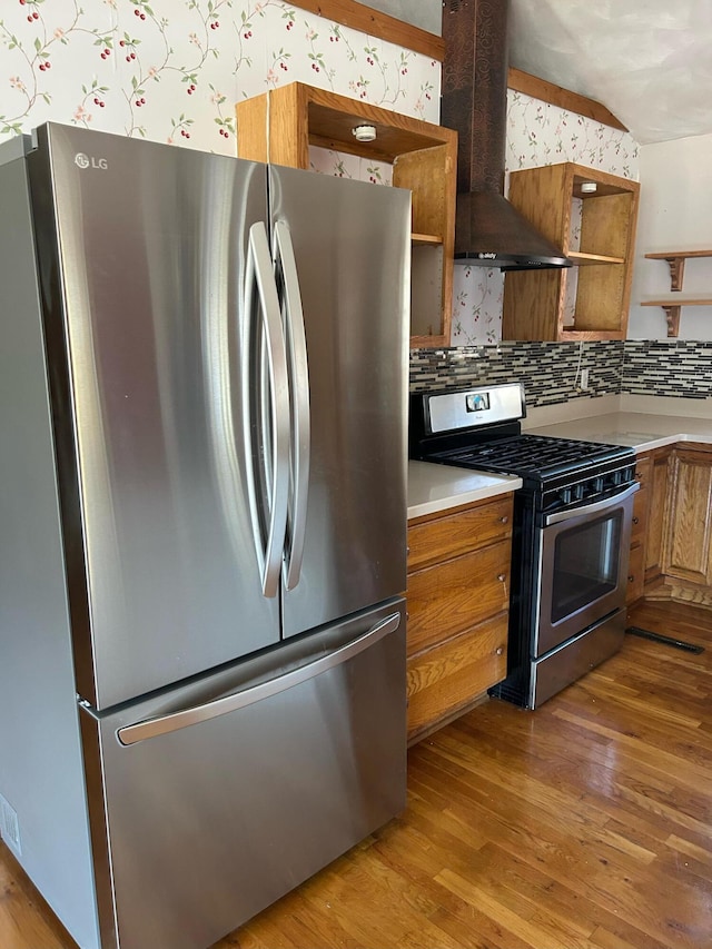 kitchen featuring stainless steel appliances, exhaust hood, light wood-type flooring, open shelves, and wallpapered walls