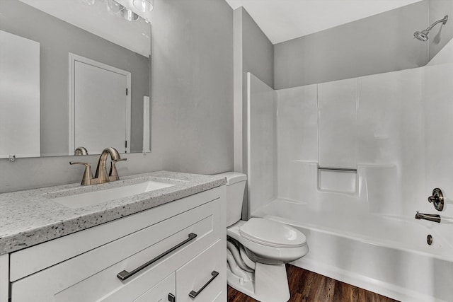 full bathroom featuring tub / shower combination, toilet, wood finished floors, and vanity