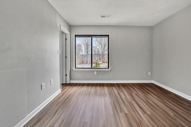 unfurnished room featuring baseboards and wood finished floors