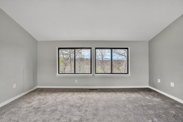 unfurnished room featuring visible vents, baseboards, lofted ceiling, and carpet