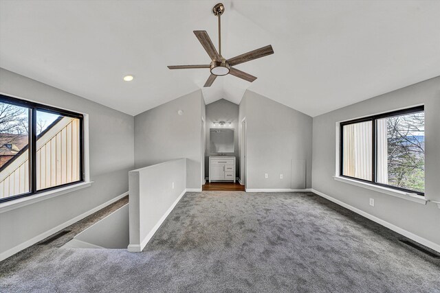 spare room featuring a ceiling fan, carpet, visible vents, baseboards, and lofted ceiling