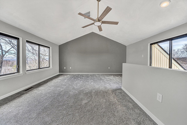 spare room featuring a healthy amount of sunlight, baseboards, carpet, and vaulted ceiling