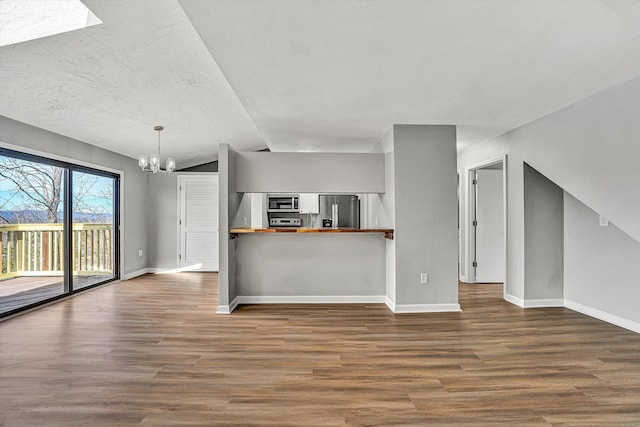 interior space with butcher block countertops, stainless steel appliances, an inviting chandelier, and dark wood-style flooring