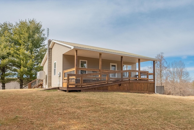 back of house featuring a deck and a lawn