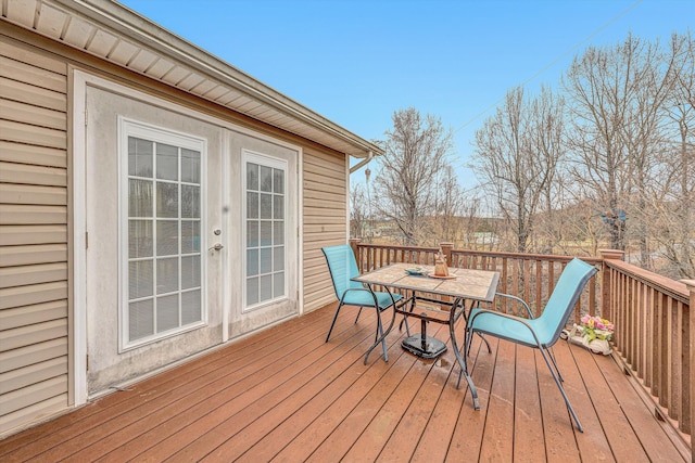 deck with french doors and outdoor dining area