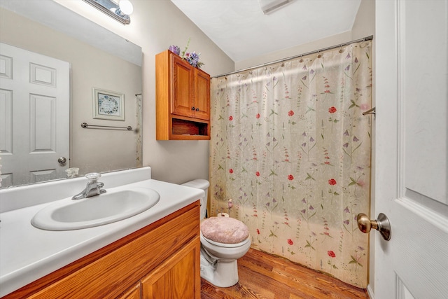 bathroom with toilet, wood finished floors, and vanity