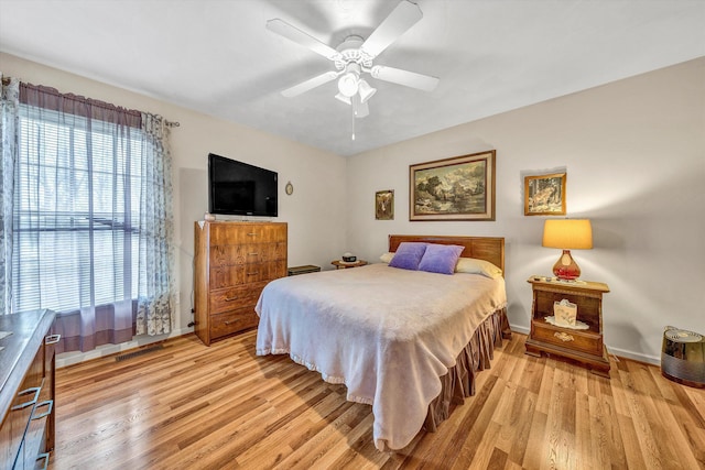 bedroom featuring a ceiling fan, light wood-type flooring, and baseboards