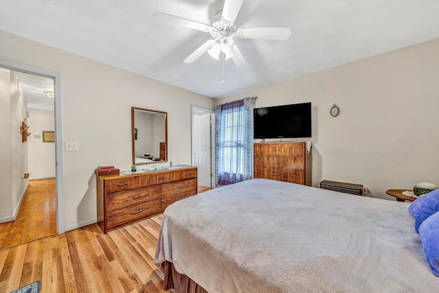 bedroom featuring baseboards, light wood-style flooring, and a ceiling fan