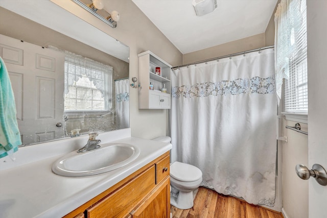 bathroom featuring visible vents, toilet, vanity, wood finished floors, and a shower with curtain