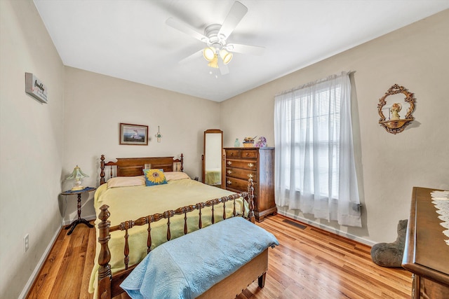 bedroom with visible vents, ceiling fan, light wood-style flooring, and baseboards