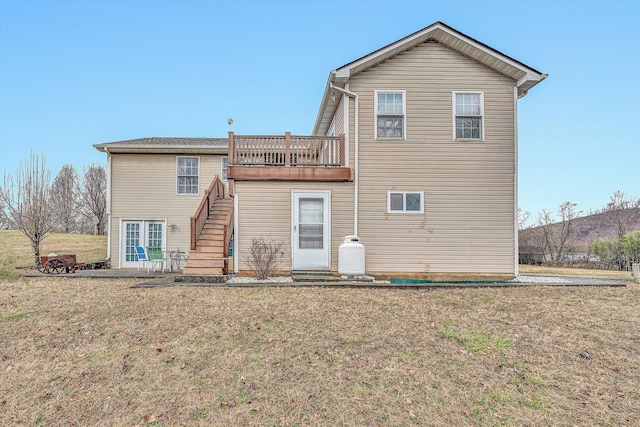 back of property with stairs and a yard