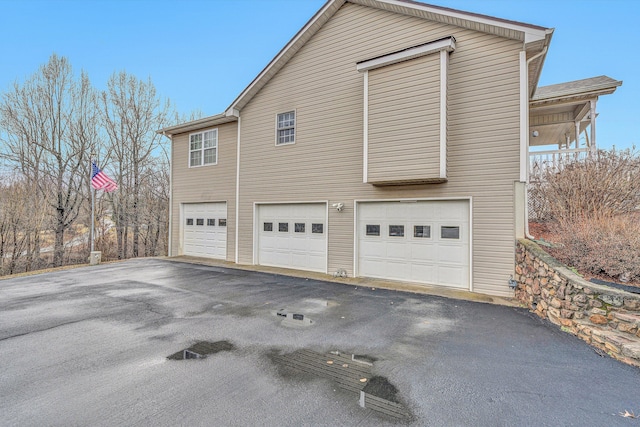 view of side of property with an attached garage and driveway