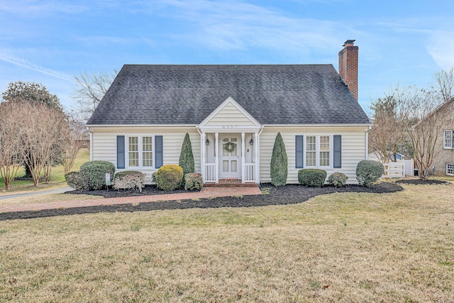 cape cod home with a chimney, a front lawn, and roof with shingles