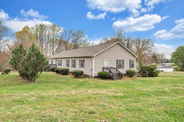 rear view of property featuring a lawn