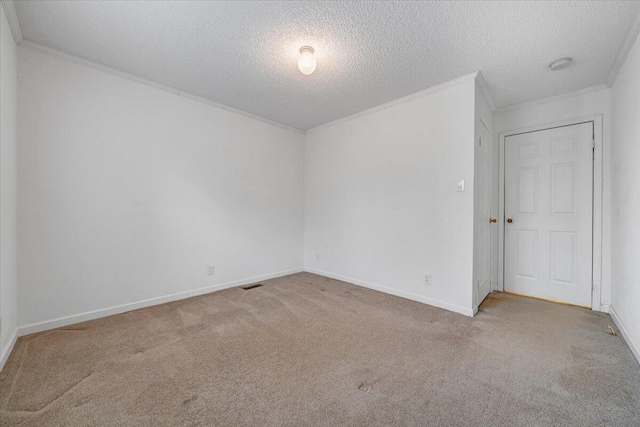 unfurnished room featuring baseboards, a textured ceiling, crown molding, visible vents, and carpet
