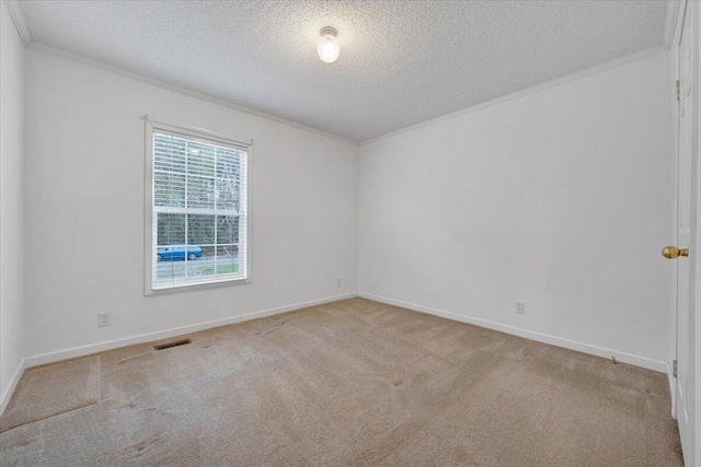 carpeted empty room featuring a textured ceiling, baseboards, ornamental molding, and visible vents