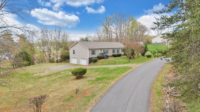 view of front of property with a garage, a front yard, and driveway