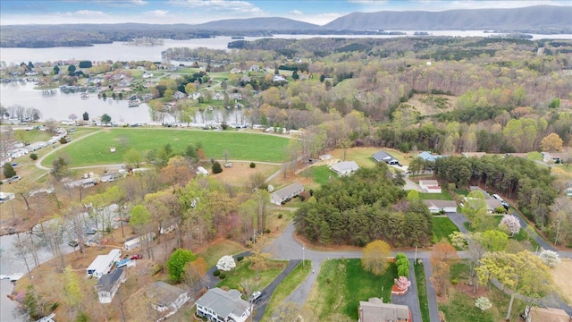 bird's eye view with a water view and a wooded view