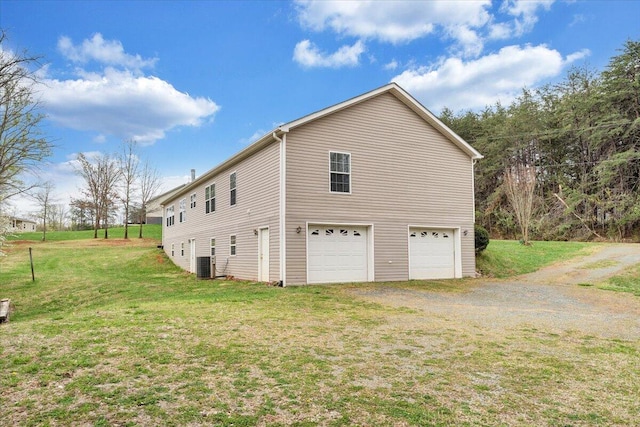 view of side of home featuring a garage, a yard, central AC unit, and driveway